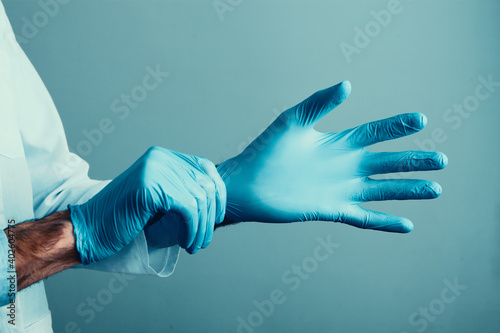 the doctor puts on the medical gloves