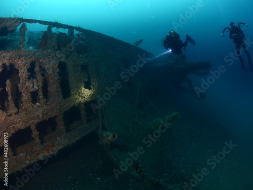 scuba divers exploring and discovering the ship wreck underwater deep sea bottom uboat submarine world war u boat photo