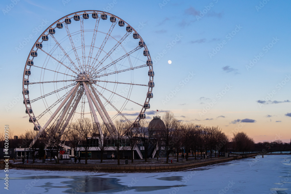Montreal, Canada - May 2020 : Ferris wheel in the old port with the full moon in the background