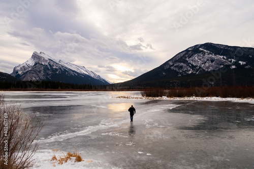 Man walking alone on the frozen Vermilion lakes  in the Banff national park  Canada