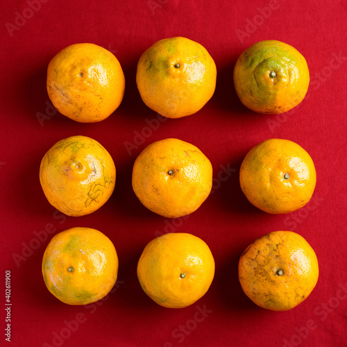 Tangerine orange fruit on red background, Top view