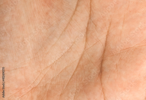 The texture of the skin of a woman's hand with lines on the palm.