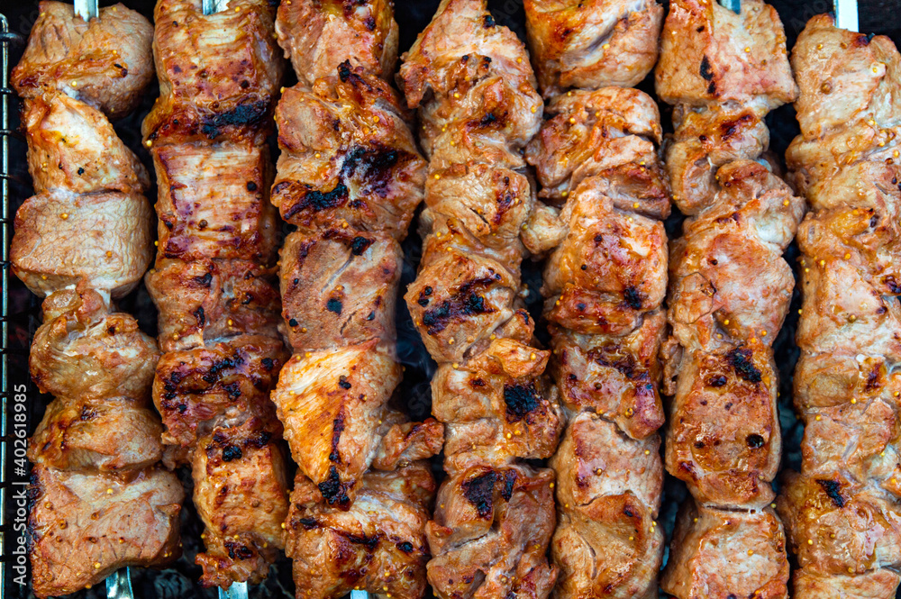 skewered pork kebab grilled over charcoal, smoke over a barbecue, medium cooking, close