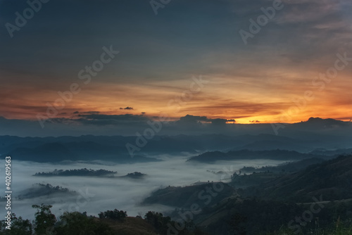 Fluffy fog stream is covering a valley with colorful twilight sky in a morning © เท้ PY15MU