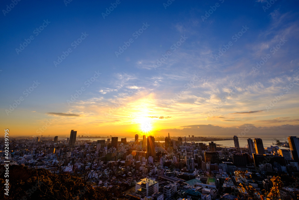 神戸、諏訪山公園・ビーナスブリッジからご来光。三宮市街地と大阪湾をのぞむ。日の出の太陽にオレンジ色に輝く雲