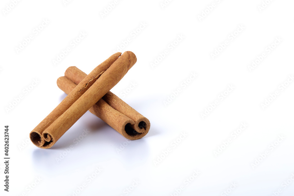 Heap of cinnamon sticks on white