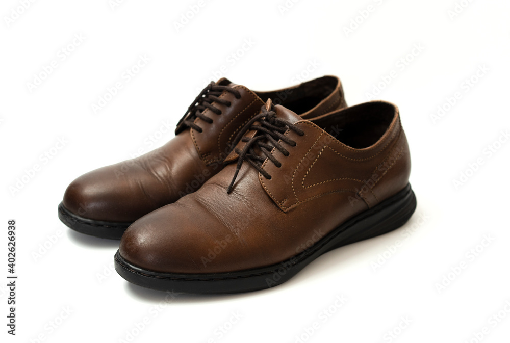 pair of brown leather shoes on white background