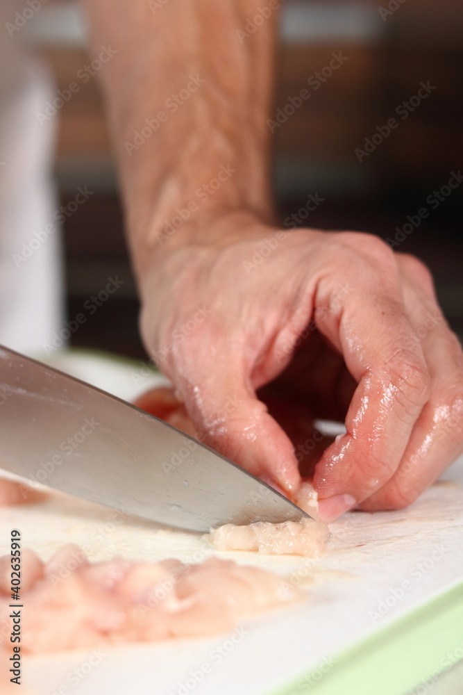 Chef cutting chicken fillet. Making Chicken and Egg Galette Series.