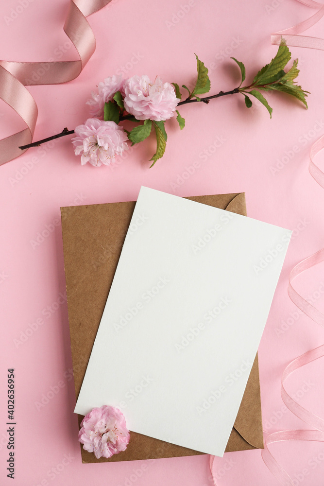 mockup of a spring postcard. blooming sakura branch on a pink background and an envelope mockup of a spring postcard. blooming sakura branch on a pink background and an envelope