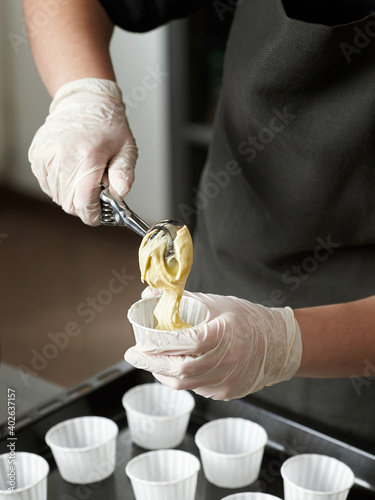 Girl pastry chef prepares muffins or cupcakes photo