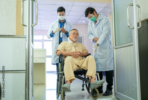 Doctor wearing protective mask to Protect Against Covid-19 talking to patient in a wheelchair at hospital corridor,Coronavirus has turned into a global emergency.