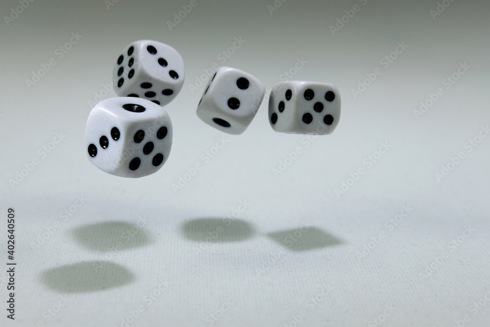 White playing dice cubes in motion on the white canvass surface, selective focus White playing dice cubes in motion on the white canvass surface, selective focus