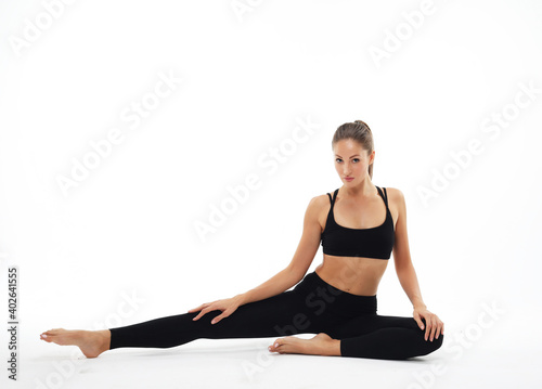 Fototapeta Naklejka Na Ścianę i Meble -  Sporty young woman doing yoga practice isolated on white background
