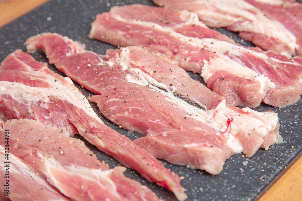 Sliced pieces of meat, on a board, pork. Close-up .