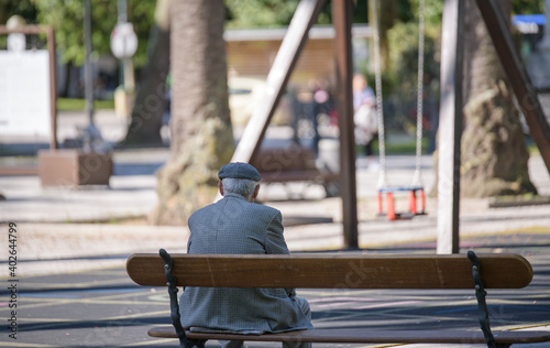 Old male sitting on a bench in the park