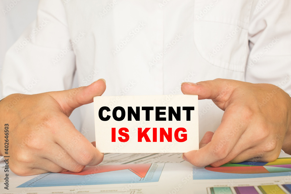 a man in the office holds a card with text CONTENT IS KING. business concept a man in the office holds a card with text CONTENT IS KING. business concept
