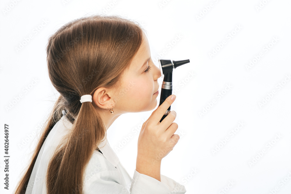 Beautiful little girl playing ophthalmologist doctor with an ophthalmoscope. Side view, white background Beautiful little girl playing ophthalmologist doctor with an ophthalmoscope. Side view, white background