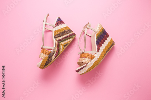Female summer sandals on a pink background close-up.