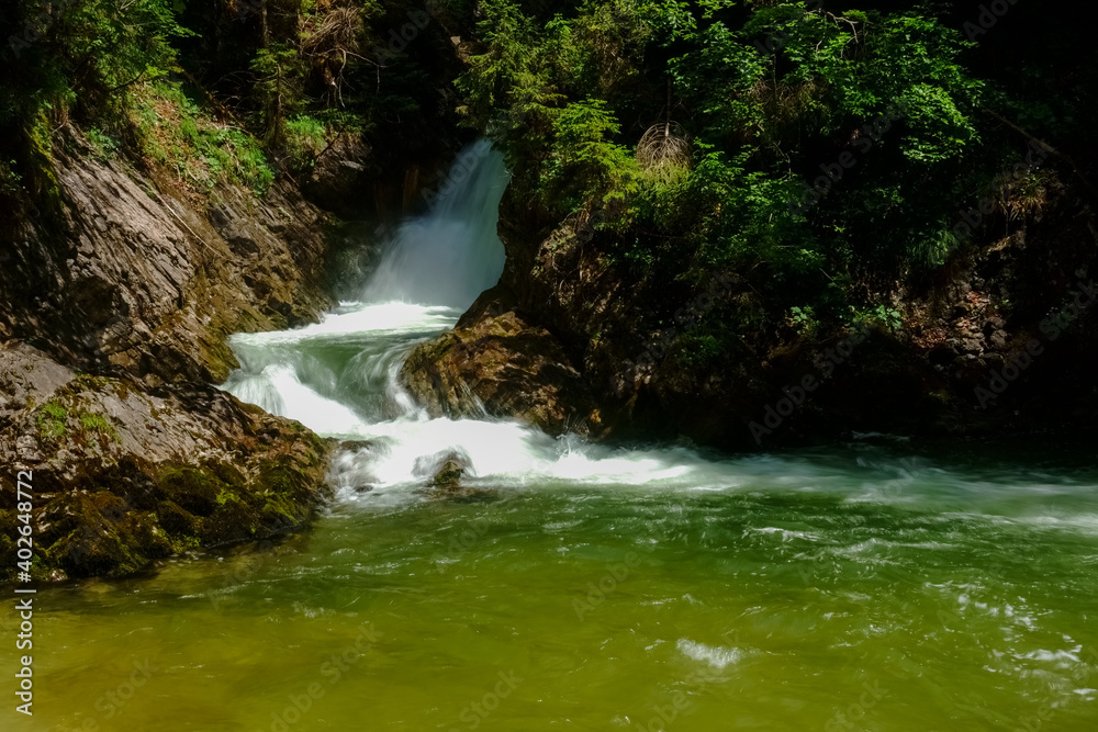 waterfall from the forest into a basin while hiking