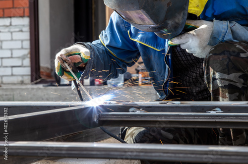 A worker welds metal at a construction site. Technology