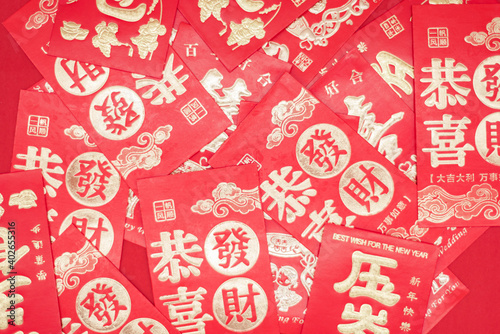 A pile of Chinese New Year red envelopes on red background