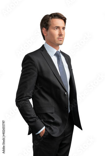Businessman in black suit standing on isolated over white background. Side view shot of young businessman hands in pockets, confident serious look