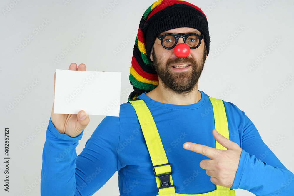 Fototapeta premium A clown in a bright costume holds a sign for the inscription.