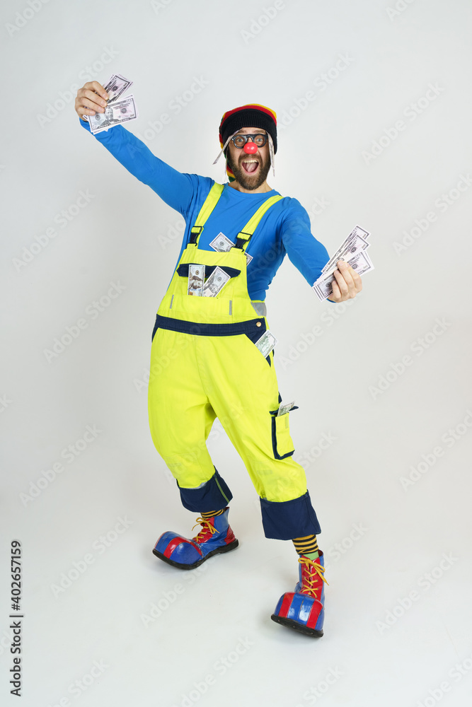 Clown in a bright suit holds money in his hands Clown in a bright suit holds money in his hands