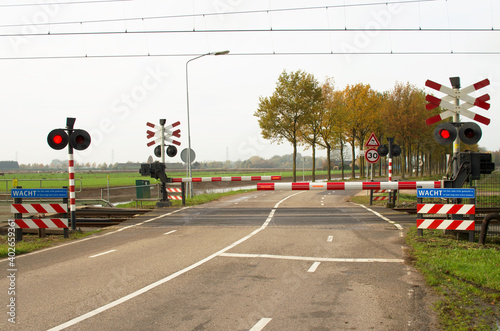 Fotografering Railway crossing with closed barriers in Arnhem, Netherlands