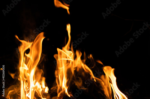 Fire flames on a black background. Abstract fiery texture. Realistic fire flames burn movement frame. Texture for Design. The texture of fire. Fire flames background. Blazing campfire. Sensitive focus