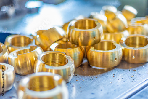 CNC-machined bronze parts lie on a rack. photo