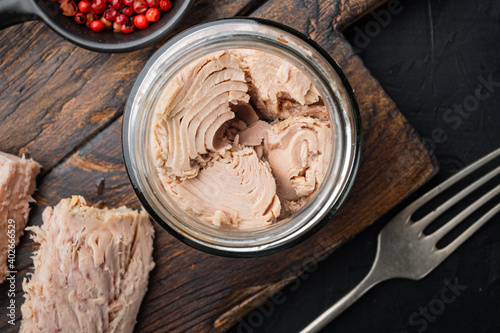 Canned tuna fillet in olive oil , on black background, flat lay