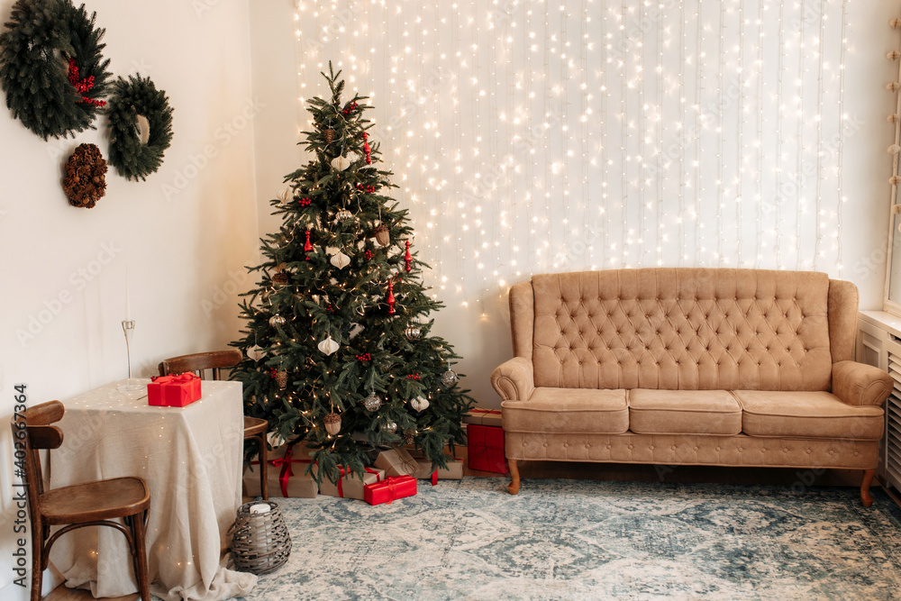 Wide image of Christmas festive decoration with garlands, Santa Claus,pillows, golden balls and fir tree.