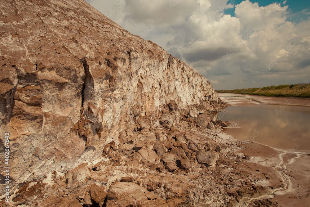 Soligork salt mine slagheap mountains and scenic nature with green grass  and dramatic cloudy sky in summer day. A technical water lake and white salt  rock Stock Photo | Adobe Stock