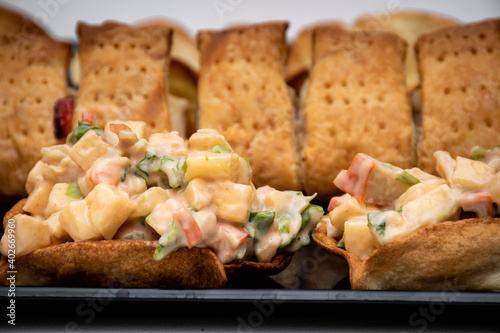 Fototapeta Naklejka Na Ścianę i Meble -  Horizontal view of puff pastry and crab cocktail tops. Crab, apple, pineapple and crab salad con white background