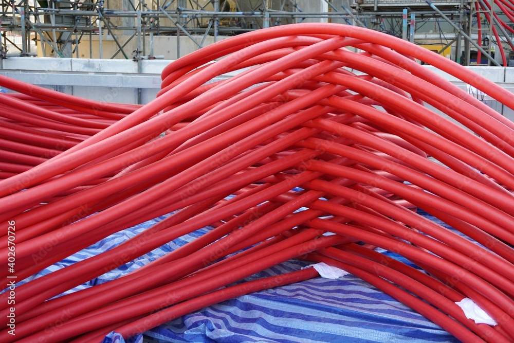 Large red power cord placed on the scaffolding floor. Large red power cord placed on the scaffolding floor.