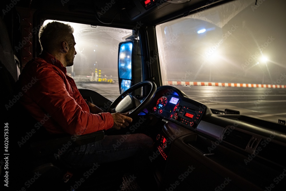 The driver at the wheel of the truck. Night course. - obrazy, fototapety, plakaty 
