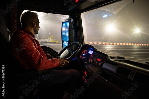 The driver at the wheel of the truck. Night course. photo