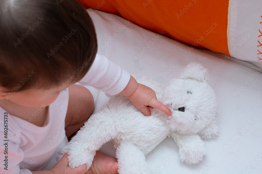 baby playing with a teddy bear