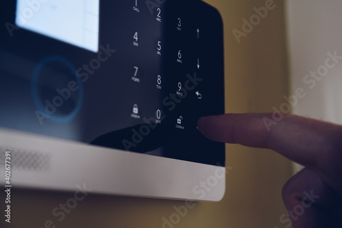 Obraz na płótnie Man disarming home security alarm entering secret pin code on alarm control panel w salonie