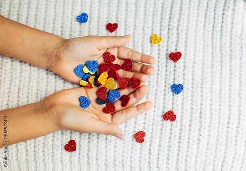 Happy valentine day. multicolored hearts in candy in hands.