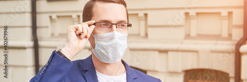 Man in protective face mask at city. Male person portrait. Lockdown concept. Sick communication. Allergy safety. Local travel. Respiratory prevention flu. Anti virus. Boy in eyeglasses