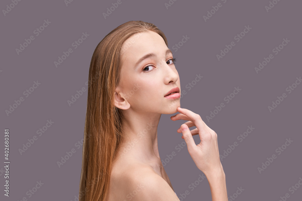 Cosmetology concept. Skin care product. Female portrait. Face mask. Home peeling. Grey background. Copyspace. Facial lifting treatment. Dermatology beauty model. Young girl. Hand near head Cosmetology concept. Skin care product. Female portrait. Face mask. Home peeling. Grey background. Copyspace. Facial lifting treatment. Dermatology beauty model. Young girl. Hand near head
