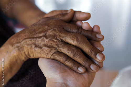 people holding hand of mother elderly that is Alzheimer and Parkinson patient. 