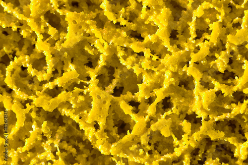 Abstract yellow plastic texture background, close up of a metal grinding disc.