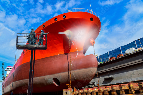 Washing and Cleaning in shipyard Worker in floating dry dock with water jet cleans the shipboard and have movement of people of the ship from sea vegetation before sandblast and paint