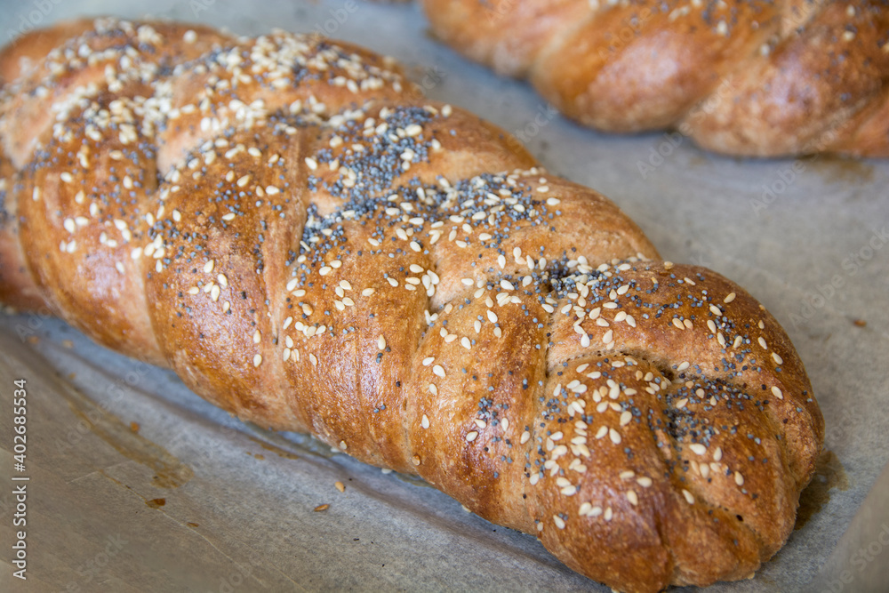 Traditional baked Challah bread, made of spelt flour, with topping of sesame and poppy seeds Traditional baked Challah bread, made of spelt flour, with topping of sesame and poppy seeds