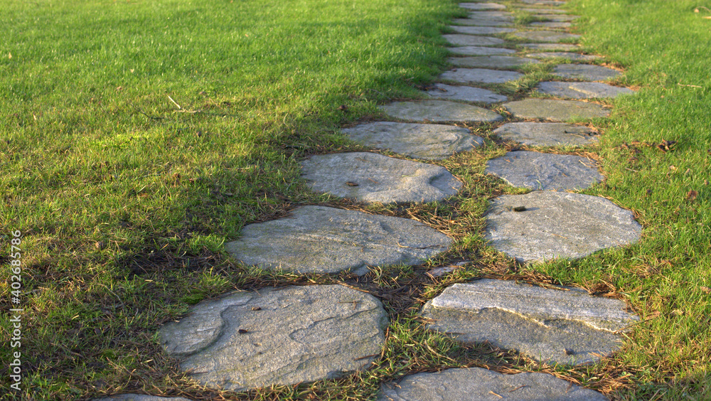 a road of big stones in green grass a road of big stones in green grass