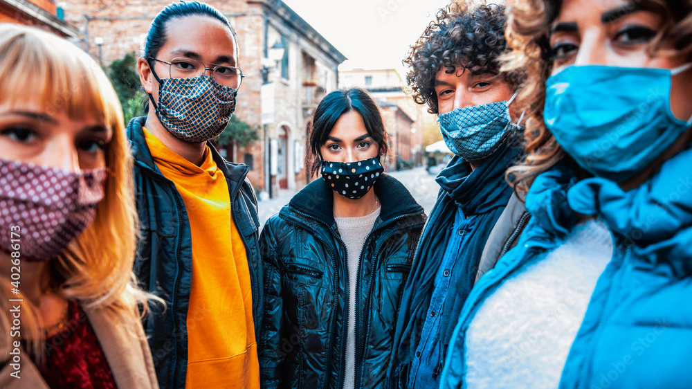Obraz premium Group of people covered by facemask looking at camera - New normal lifestyle concept with crowd of citizens wearing protective mask walking on city street