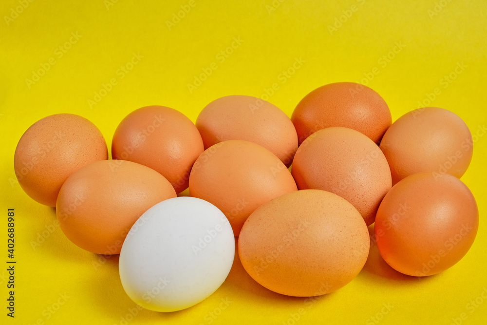 Chicken eggs on a yellow background are brown and white. Chicken eggs on a yellow background are brown and white.